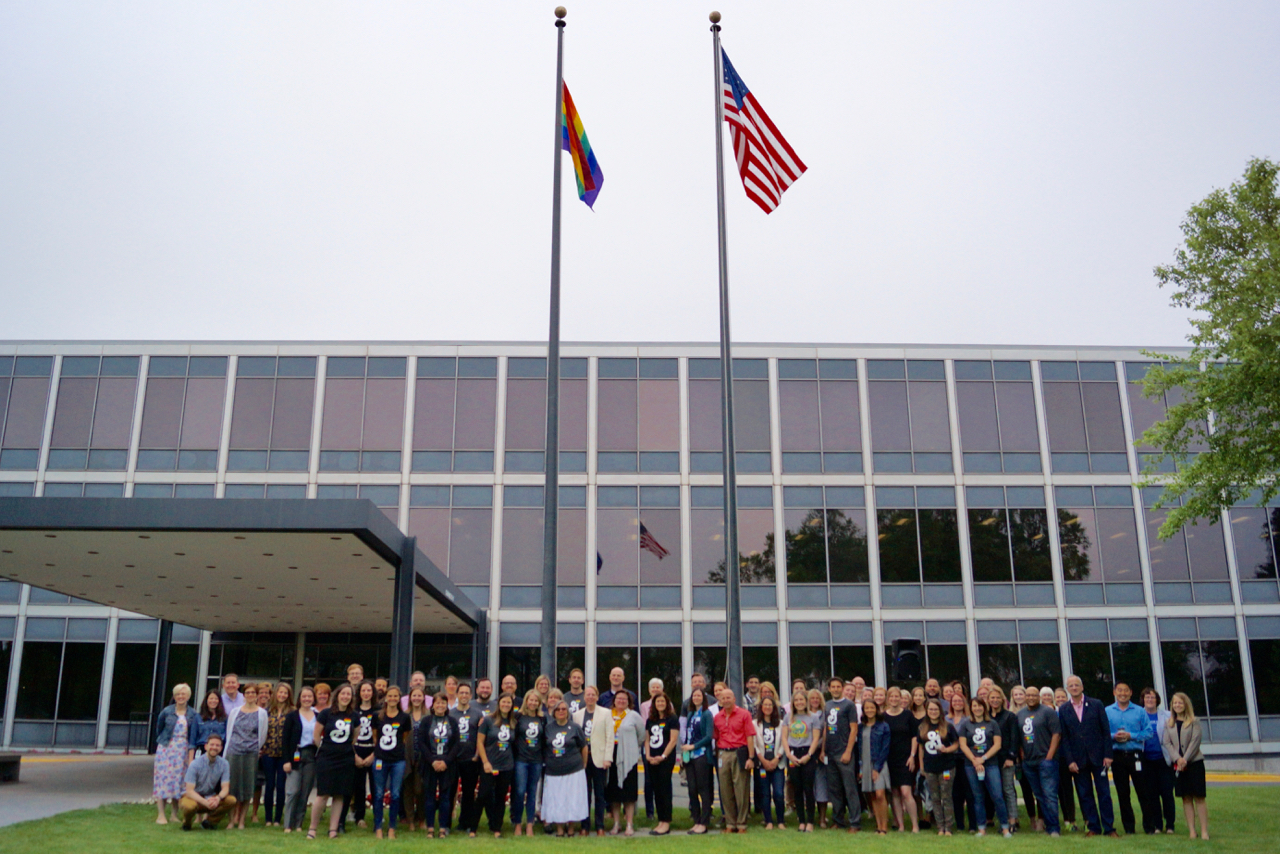 General Mills employees standing below Pride Flag